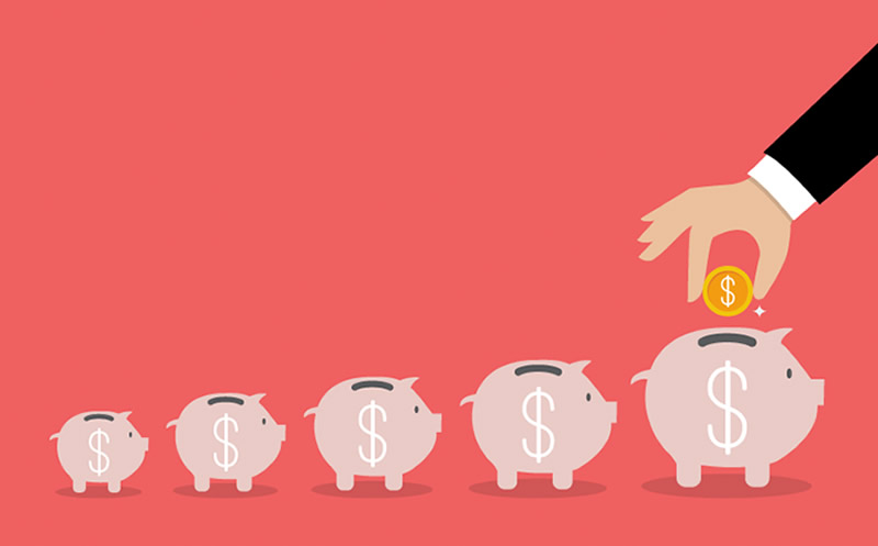A photo of someone putting money in a piggy bank.