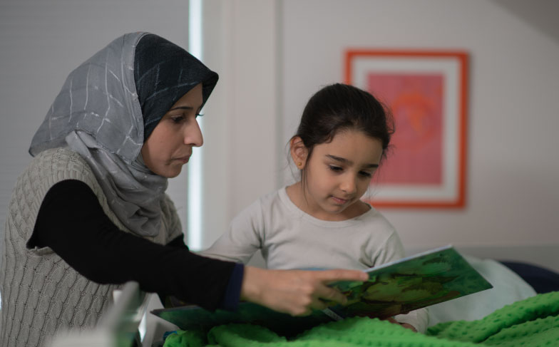 A photo of a mom reading with her daughter.