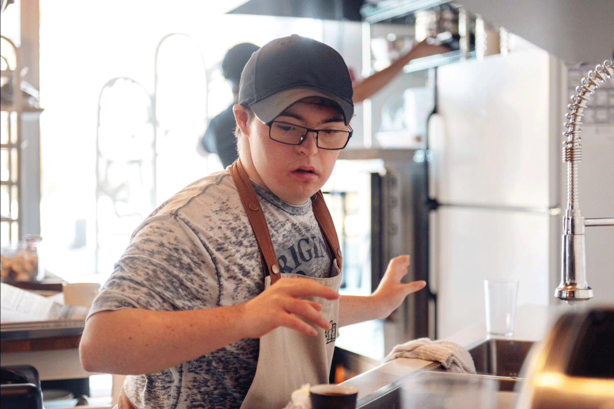 A photo of someone busy cooking in a commercial kitchen at a restaurant.
