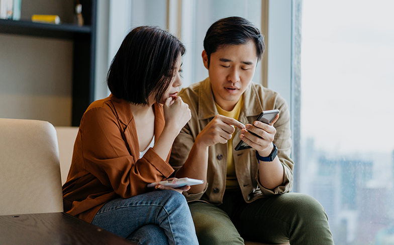 Couple looking through support options on mobile device.