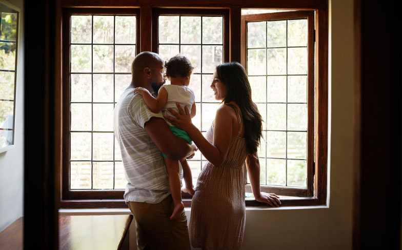 Family looks out window of home.