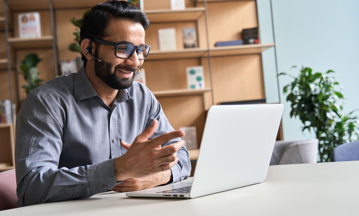 A photo of a person working at a desk in front of their computer.