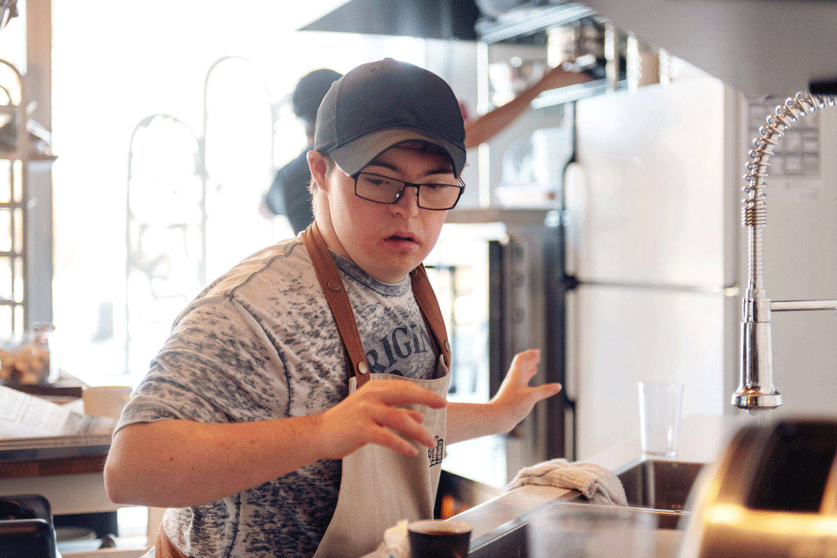 A photo of someone cooking in a commercial restaurant kitchen.
