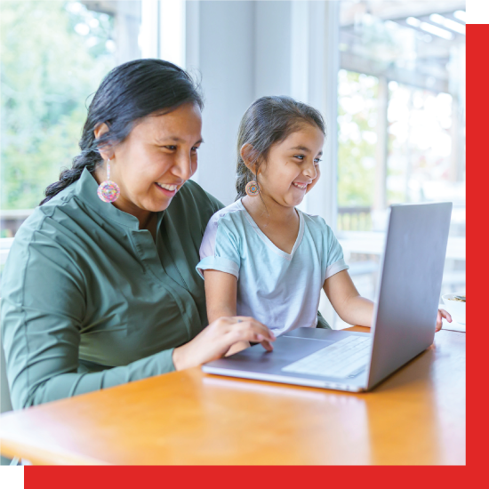 A photo of a mother and daughter chatting with family online.