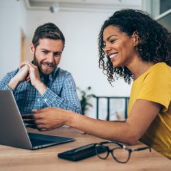 A photo of two people working on a project in an office.